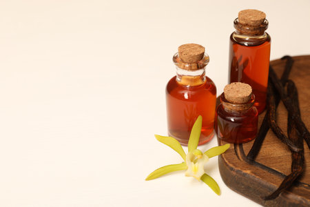 Aromatic vanilla extract, pods and flower on white table. Space for textの写真素材
