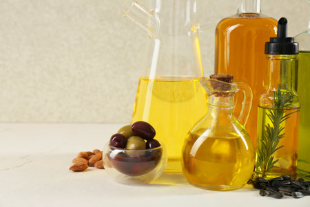 Vegetable fats. Different cooking oils in glass bottles and ingredients on white table, space for textの写真素材