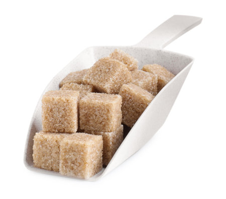 Brown sugar cubes in scoop isolated on whiteの写真素材