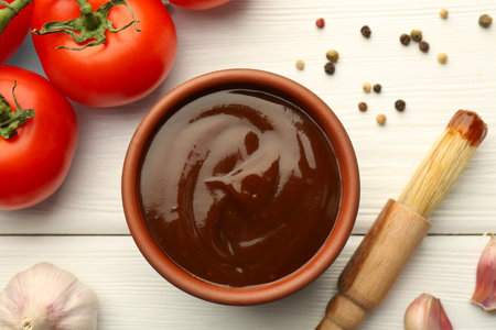 Flat lay composition with tasty barbeque sauce in bowl on white wooden tableの写真素材