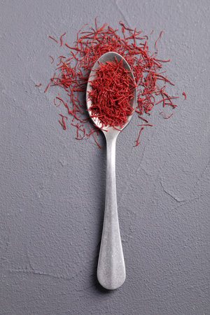 Aromatic saffron and spoon on gray table, top viewの写真素材