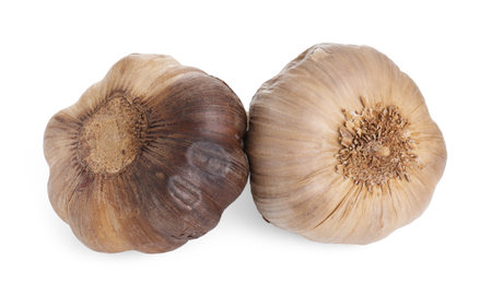 Bulbs of fermented black garlic isolated on whiteの写真素材