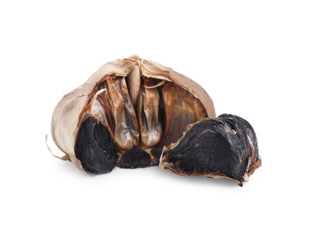 Bulb and clove of fermented black garlic isolated on whiteの写真素材