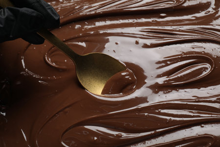 Person making tasty milk chocolate paste, closeup