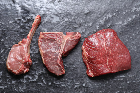 Fresh raw beef cuts on gray textured table, flat layの写真素材