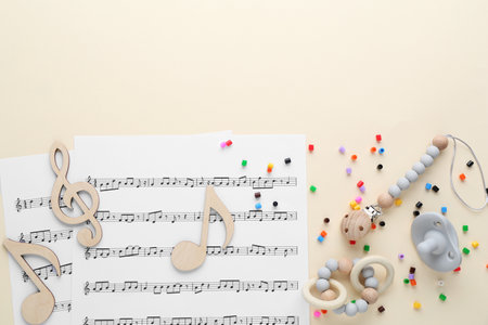 Wooden notes, music sheets and toys on beige background, flat lay with space for text. Baby song conceptの写真素材