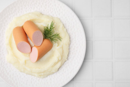 Delicious boiled sausages, mashed potato and dill on white tiled table, top view. Space for textの写真素材