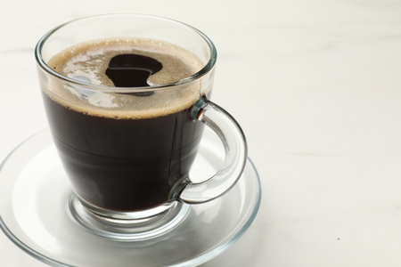 Cup of aromatic coffee on white table, closeup. Space for textの写真素材