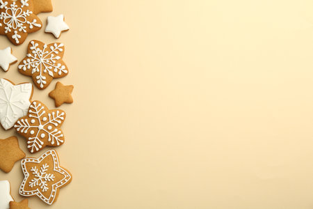 Tasty Christmas cookies with icing on beige background, flat lay. Space for textの写真素材