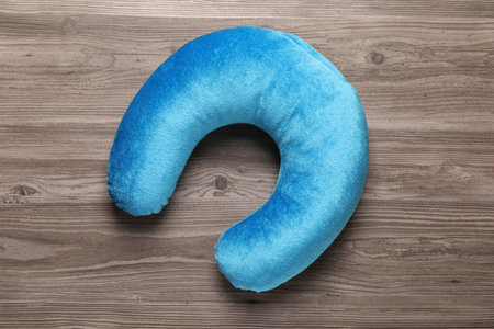 Light blue travel pillow on wooden table, top viewの写真素材