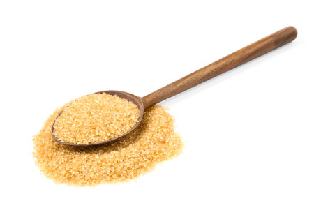 Pile of brown sugar and wooden spoon isolated on whiteの写真素材