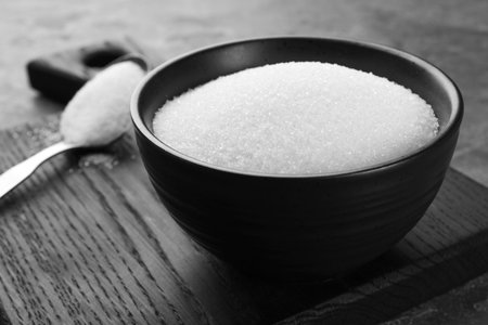 Granulated sugar in bowl on gray table, closeupの写真素材