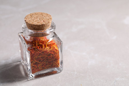 Aromatic saffron and glass jar on light gray table, space for textの写真素材