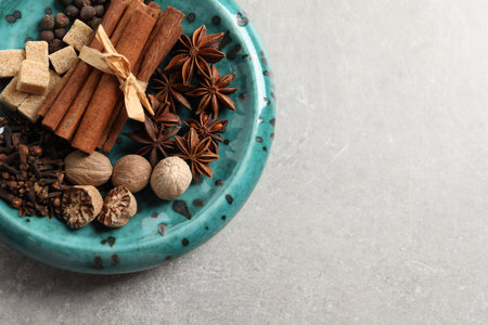 Different aromatic spices on light textured table, top view. Space for text