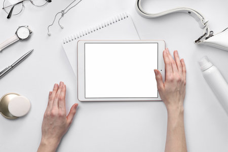 Woman with modern tablet on white background, top view. Space for textの写真素材
