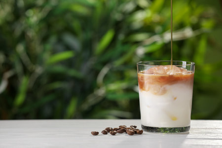 Making iced coffee at white wooden table outdoors, closeup. Space for text
