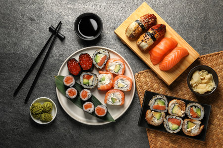 Flat lay composition with delicious sushi rolls on dark gray tableの写真素材