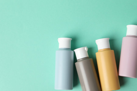 Cosmetic travel kit on turquoise background, flat lay. Space for textの写真素材