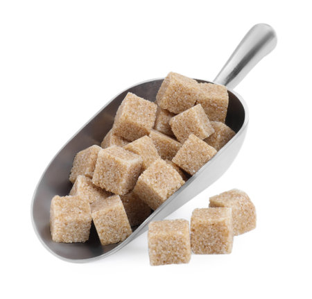 Brown sugar cubes in metal scoop isolated on whiteの写真素材