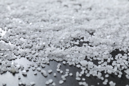Scattered natural salt on black table, closeupの写真素材