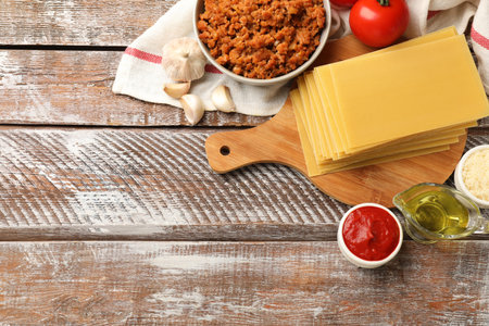 Flat lay composition with products for cooking lasagna on wooden rustic table. Space for textの写真素材