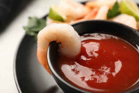 Tasty boiled shrimps with sauce cocktail, parsley and lime on light gray table, closeupの写真素材