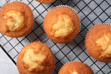 Delicious sweet muffins on gray textured table, top view