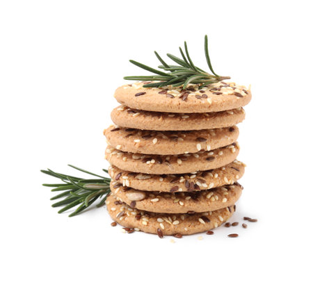 Stack of round cereal crackers with flax, sunflower, sesame seeds and rosemary isolated on whiteの写真素材