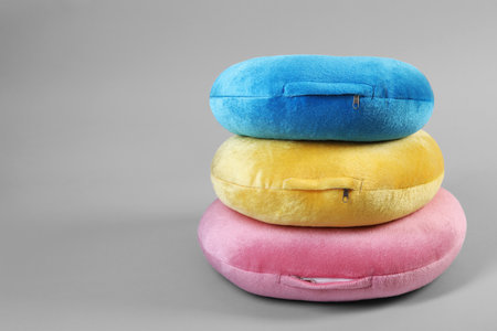 Stack of travel pillows on light gray background, space for textの写真素材