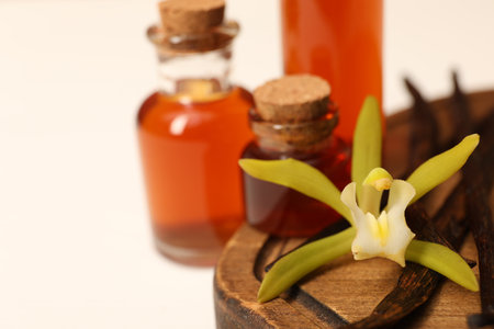 Aromatic vanilla extract, pods and flower on white table, closeup. Space for textの写真素材
