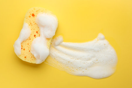 Sponge with foam on yellow background, top view. Space for textの写真素材