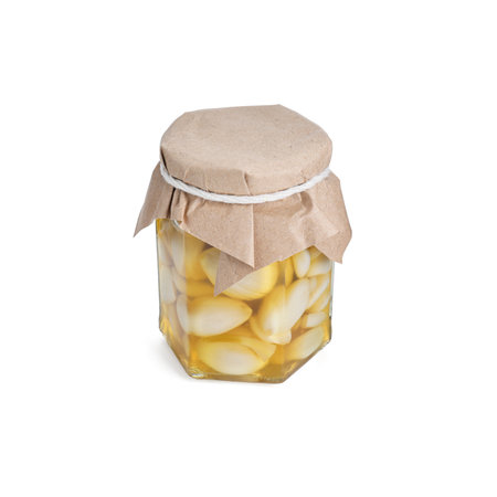 Garlic with honey in glass jar isolated on whiteの写真素材