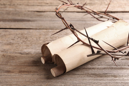 Crown of thorns and old scrolls on wooden table, closeupの写真素材