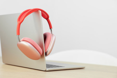 Modern laptop and headphones on wooden table. Space for textの写真素材