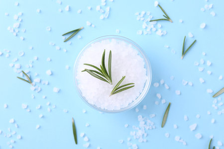 Salt and rosemary in bowl on light blue background, flat layの写真素材