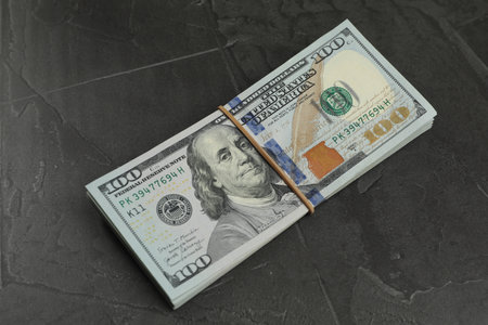 Money exchange. Dollar banknotes on dark gray textured backgroundの写真素材