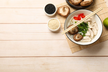 Delicious ramen with meat and ingredients on wooden table, flat lay. Space for text