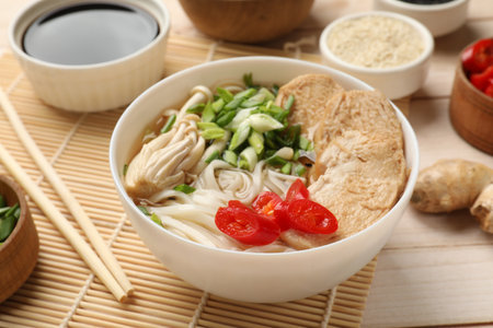 Delicious ramen with meat and ingredients on white wooden table, closeup. Noodle soupの写真素材