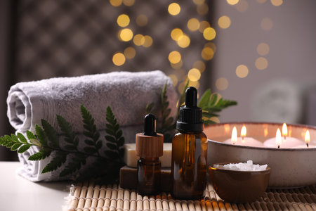 Beautiful composition with different spa products on table against blurred lightsの写真素材