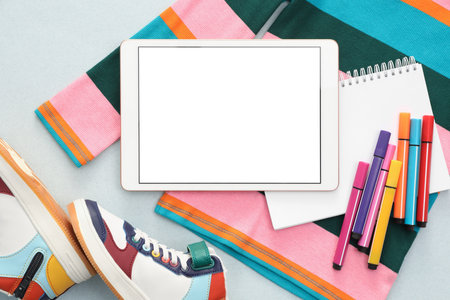 Modern tablet, clothes and stationery on light background, flat lay. Space for textの写真素材