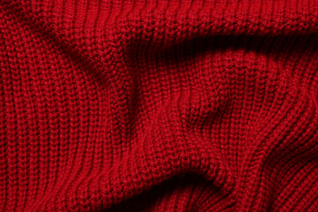 Texture of soft red knitted fabric as background, top viewの写真素材