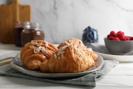 Delicious croissants with almond flakes on white wooden table, closeupの写真素材