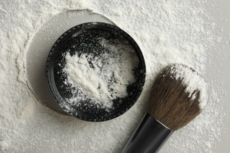 Rice loose face powder and makeup brush on light gray background, flat layの写真素材