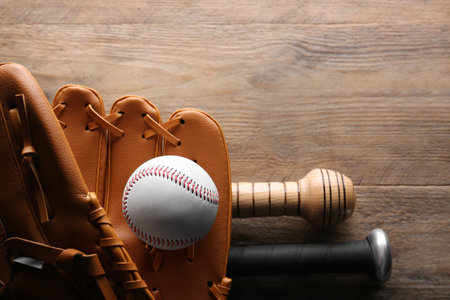 Baseball glove, bats and ball on wooden table, flat lay. Space for textの写真素材