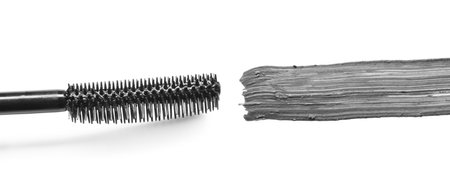 Smear of black mascara and applicator isolated on whiteの写真素材