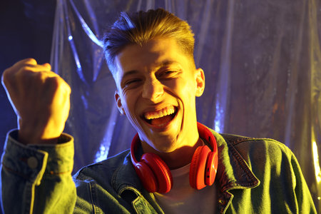 Young man with headphones in neon lights