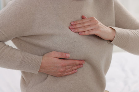 Mammology. Woman doing breast self-examination indoors, closeupの写真素材