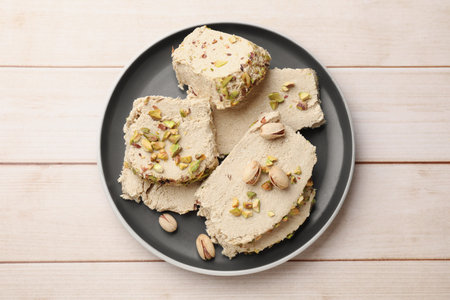 Pieces of tasty halva with pistachios on wooden table, top viewの写真素材