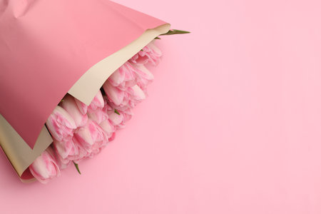 Beautiful bouquet of fresh tulips on pink background, top view. Space for textの写真素材