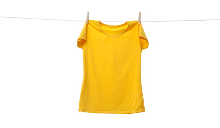 Yellow t-shirt drying on washing line against white backgroundの写真素材